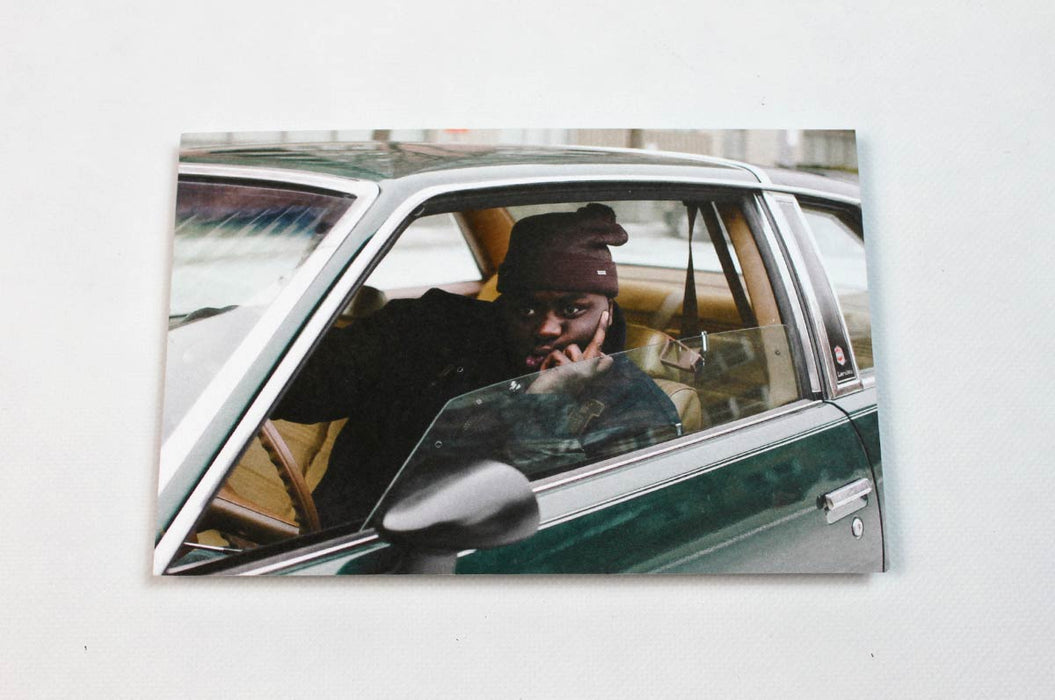 Custom 14pt uncoated matte postcard with a photographic print of an African American man sitting inside a vintage car on a white background