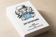 A stack of white letterpress cotton cards with a black line-art illustration and 'CLUB CARD' logo embossed on a filed of iridescent foil