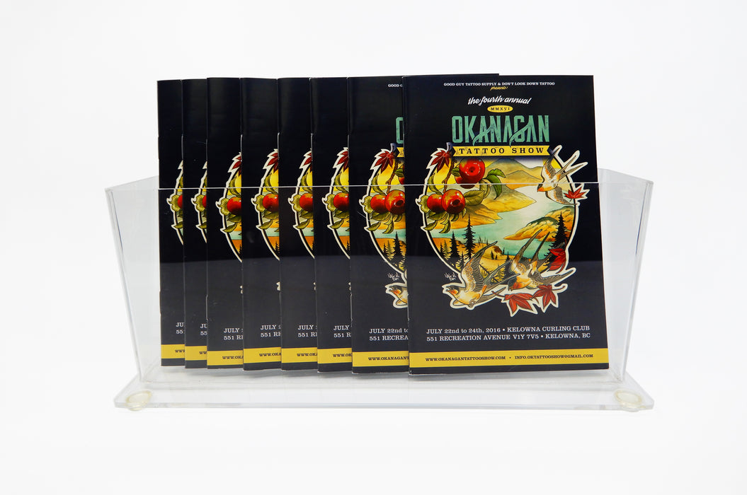 Clear acrylic rack card stand holding 8 saddle stitch booklets for the 2016 Okanagan Tattoo Show.